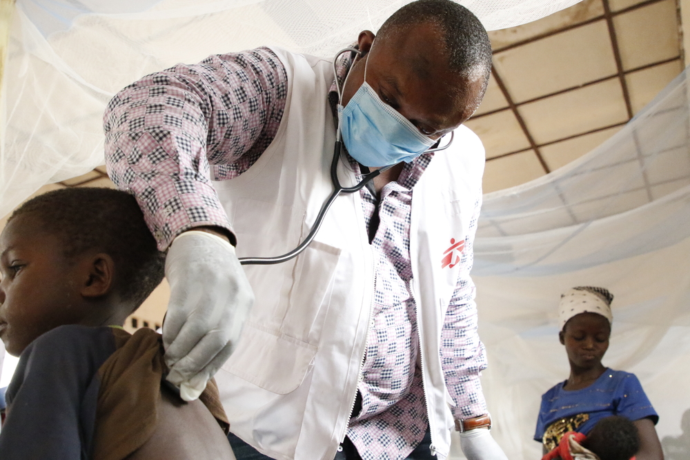 Theophile, médico del equipo de emergencias de MSF, examina a un niño con sarampión en el hospital general de Bosobolo. Febrero de 2021 