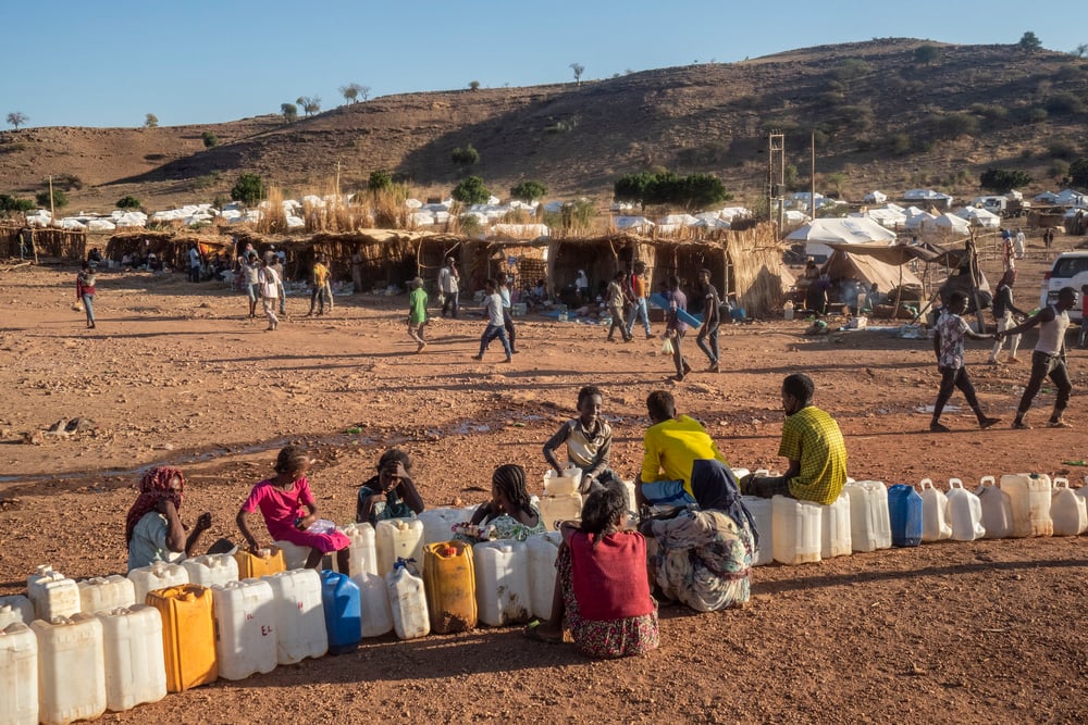 Personas refugiadas esperan para cargar agua en bidones, en el campo de refugiados de Um Rakuba ubicado en  Sudán, cerca de la frontera con la región etíope de Tigray. Diciembre de 2020