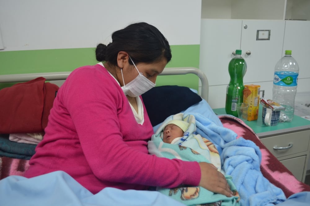 Una paciente en sala de post parto junto a su bebé, en el Centro de Salud San Roque en la ciudad del El Alto. Bolivia, abril de 2021