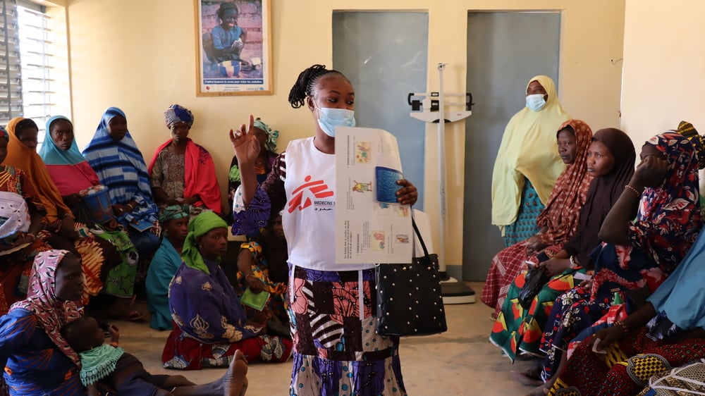 Una de nuestras promotoras de salud brinda educación sobre temas relacionados con salud e higiene a un grupo de mujeres que esperan ser atendidas en la sala de maternidad del centro de salud de Wendou, en la región del Sahel. Burkina Faso, febrero de 2021