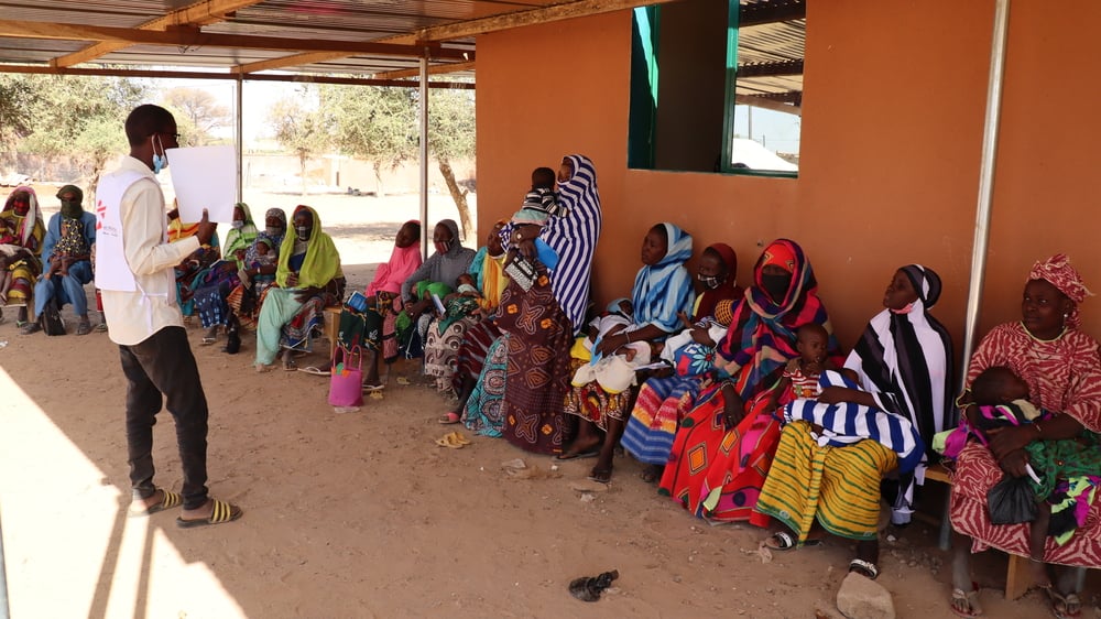 Uno de nuestros promotores de salud habla con un grupo de mujeres mientras esperan a ser atendidas en la sala de maternidad del hospital de Gorom Gorom, en la región del Sahel. Burkina Faso, febrero de 2021