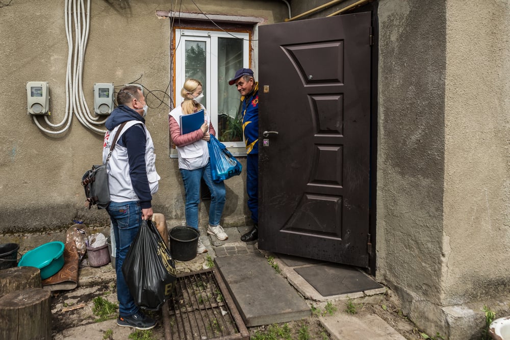Dos integrantes de nuestros equipos de apoyo, Oksana Vykhivska y Oleksandr Vovkogon (trabajadora social y enfermero), le entregan paquetes de comida en su casa al paciente de TB Vitalii Gorbachov, de 56 años, en el distrito de Chudniv.