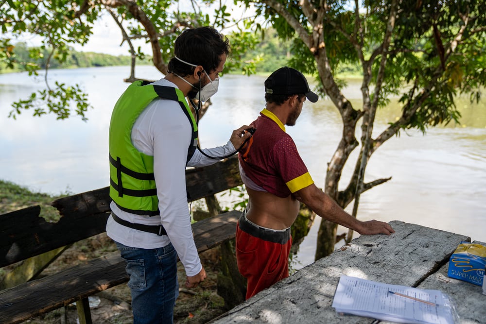 Eduardo Rugani, médico de MSF, examina a un paciente al lado del río Anapu. Brasil, julio de 2021
