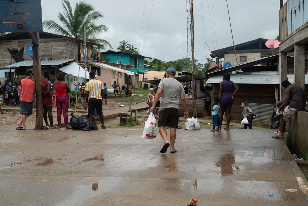 Plaza principal de Bajo Chiquito, pueblo en la comarca indígena Emberá-Wounaan. Allí, las autoridades recuentan a las personas migrantes para poder descenderlas en piraguas a las Estaciones de Recepción Migratoria. Panamá, junio de 2021