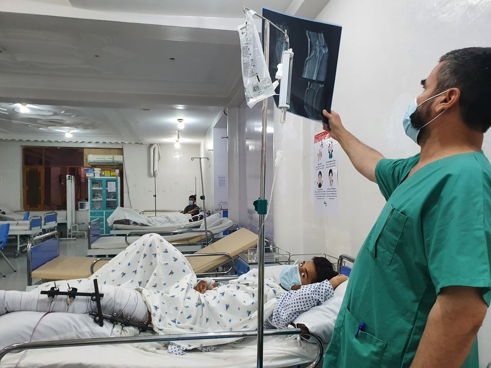 En la sala de urgencias de nuestra unidad de traumatología en Kunduz, un médico examina la radiografía de un paciente que ha sufrido una fractura en su pierna debido a la explosión de una bomba. Afganistán, julio de 2021