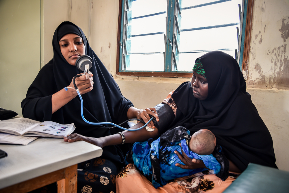 Salma, enfermera de MSF, controlando la presión arterial de una madre con diabetes que ha llevado a su hijo a la clínica.
