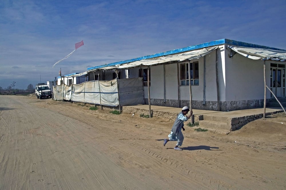 Un niño remonta un barrilete frente a nuestra clínica en la región de Puli Khumri, provincia de Baghlan. Afghanistan, marzo de 2004