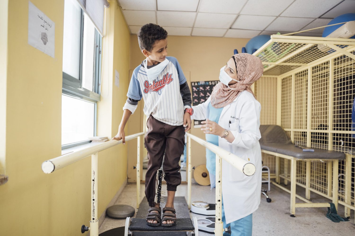 Ahmed , un niño de 11 años herido en una explosión en Yemen, en una sesión de recuperación con Rula Marahfeh, fisioterapia de nuestra organización. Hospital de Amán, Jordania, junio de 2021.Peter Bräunig.