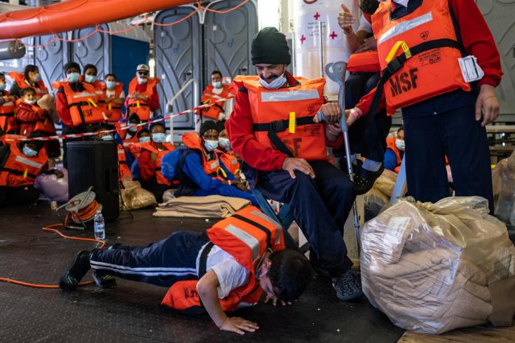 Adam hace flexiones delante de su padre y sus hermanos mientras esperan el desembarco en Messina (Sicilia).