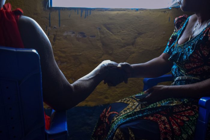 Imagen de archivo del 18 de diciembre de 2021: una paciente víctima de violencia sexual en Salamabila se encuentra junto a una integrante de su familia que sostiene su mano.Norah Mbadu/MSF.