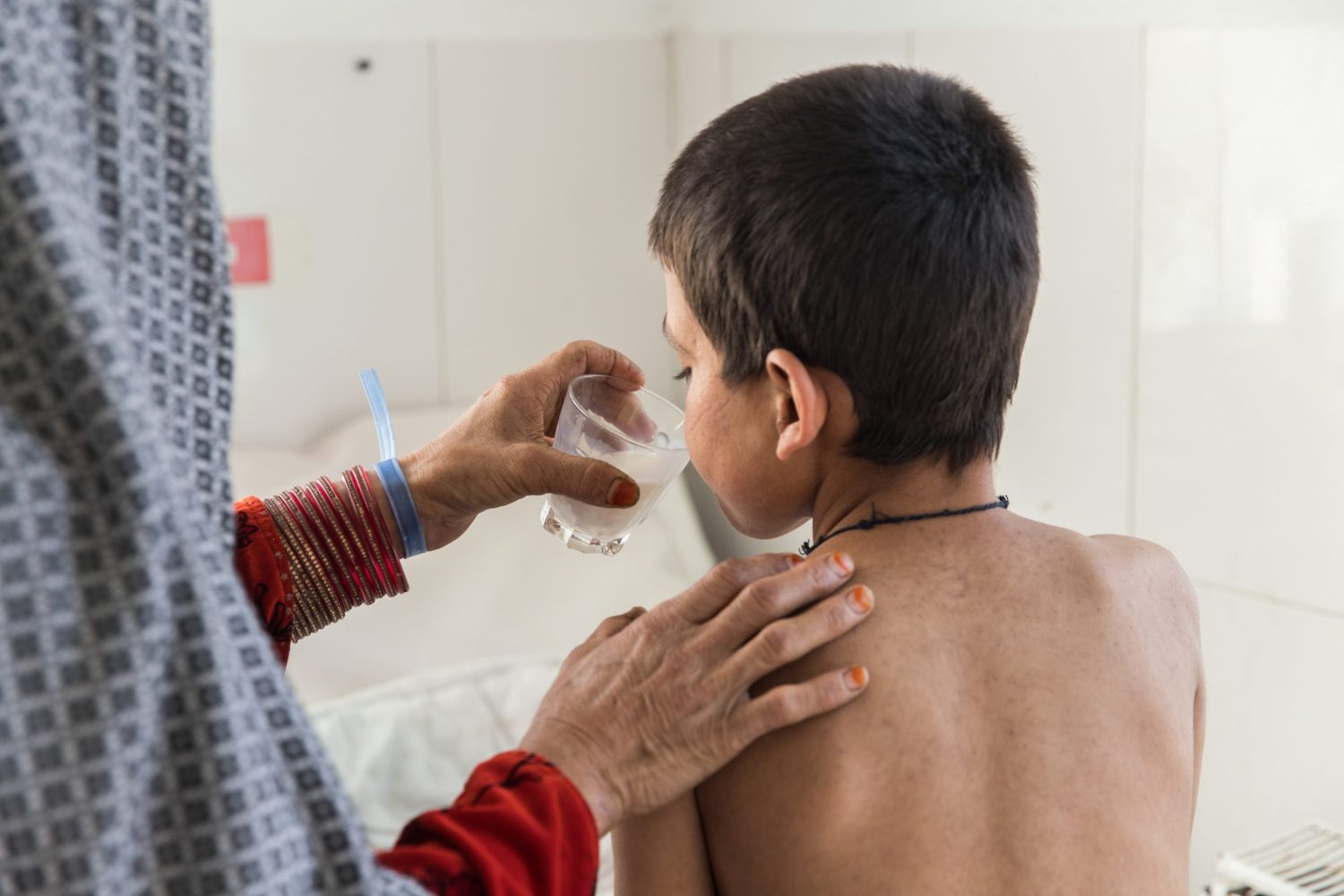 Saed Bibi le da un vaso de leche a su hijo Saddiqulah, de 10 años, en el departamento de pediatría del hospital Boost.Oriana Zerah.
