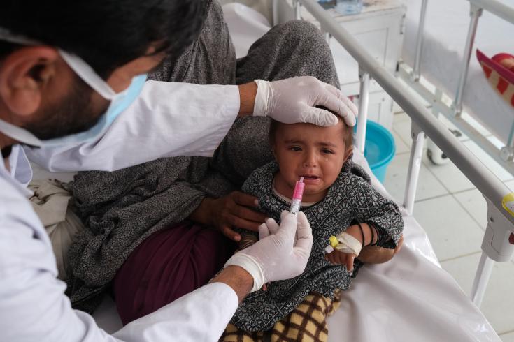 Un médico le da glucosa a un paciente en la sala de aislamiento del sarampión en el hospital Boost Afganistán