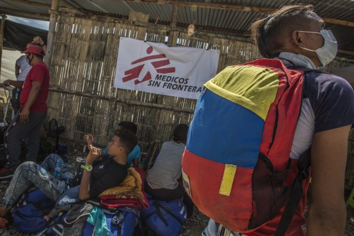 Migrante venezolano en el puesto de salud de MSF en Aguas Verdes, Perú, aguarda el colectivo que lo llevará a Tumbes. Lleva puesta una mochila con los colores de la bandera de su país.Max Cabello Orcasitas.