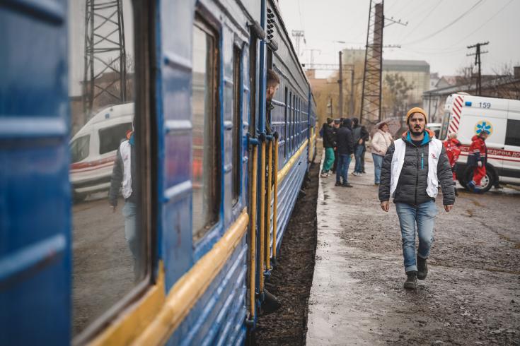 Maarten Bullens, coordinador médico de MSF en Ucrania, ayudando a supervisar el traslado de pacientes a las ambulancias desde el tren de derivación médica, a su llegada a Leópolis el viernes 1 de abril de 2022.