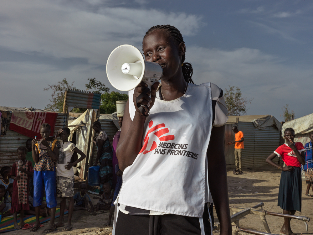 Uno de nuestros grandes logros del 2022: realizamos la primera campaña de vacunación masiva del mundo contra un brote de hepatitis E en el campo de personas desplazadas internamente de Bentiu, en Sudán del Sur.
En la foto, una promotora de salud de nuestra organización ayuda a movilizar a los miembros de la comunidad de Bentiu para que se vacunen.Peter Caton.