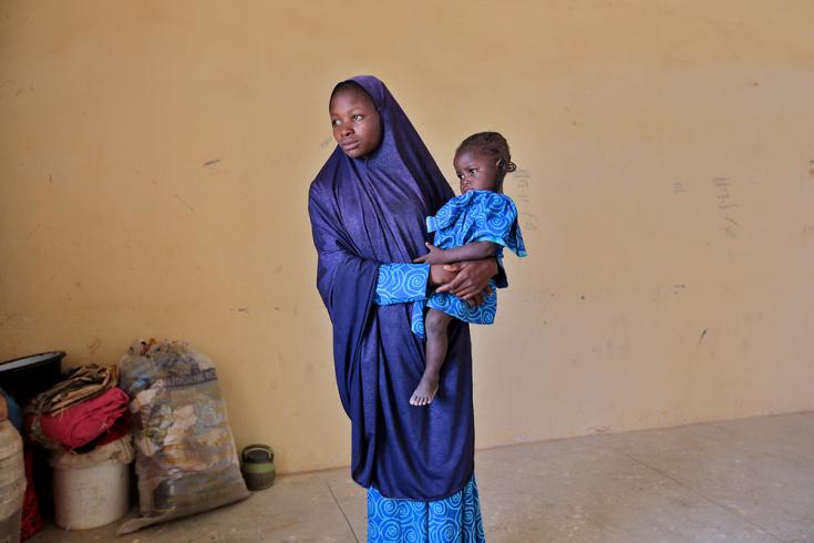Bashira Musa con su bebé en un aula en donde las personas desplazadas internamente encontraron un refugio para huir de la violencia en Jibia, Katsina, en Nigeria
