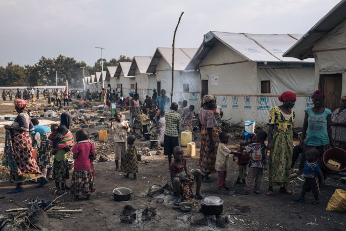 Un grupo de personas desplazadas prepara comida en frente de los refugios comunales del campo informal para personas desplazadas internamente de Rutshuru, en Kivu del Norte, al este de República Democrática del Congo.Alexis Huguet.