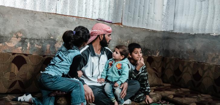 Ahmed con tres de sus hijos en su refugio improvisado.
