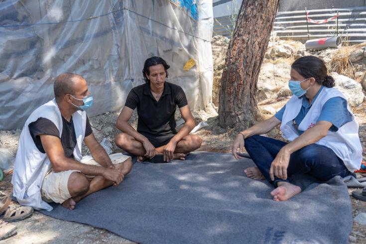 Director general de MSF Suiza (derecha), habla con Ali Al Ahmed (centro), un sirio de 30 años que vive en el campo de refugiados de Vathy en Samos desde noviembre de 2019.
