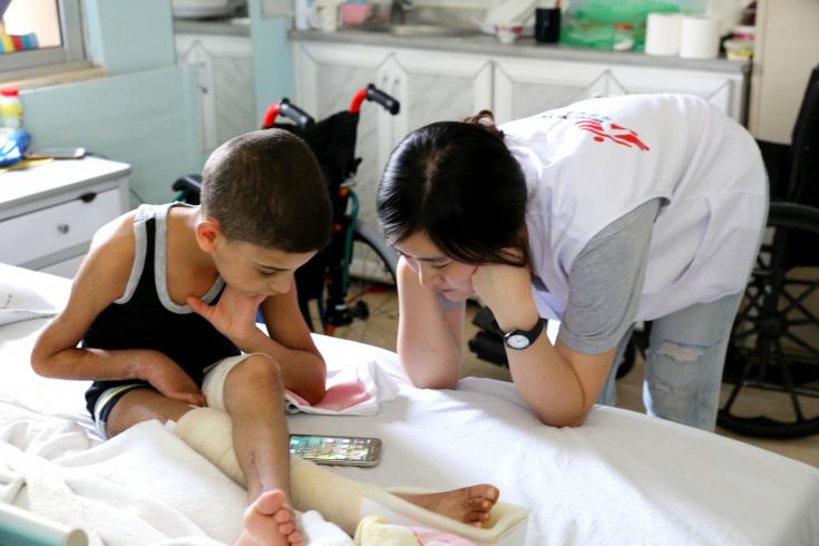 Enfermera junto a un niño Sirio atendido en el Hospital de Ramtha, Jordania