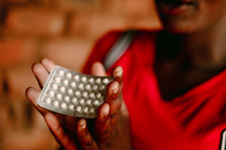 Foto tomada en Malaui, 2019. Una trabajadora sexual sostiene anticonceptivos durante una sesión de promoción de la salud.