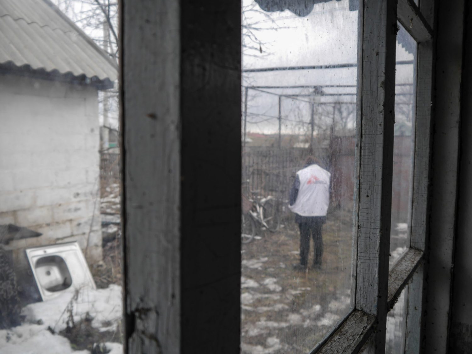 Foto de archivo: miembro de MSF afuera de una casa abandonada que funciona como clínica móvil en Vodiane, Ucrania (2019). Nico Dauterive.