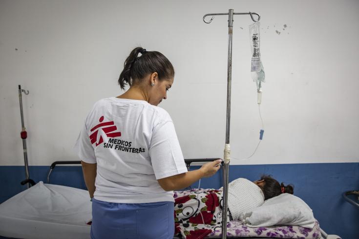 Médica asiste a una niña infectada de dengue en Honduras.
