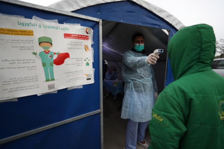 En un hospital que apoyamos en el noroeste de Siria, un médico verifica la temperatura de un paciente en un espacio para identificar síntomas de COVID-19, para luego trasladarlos a observación si es necesario y llamar a una ambulancia y realizar el test.