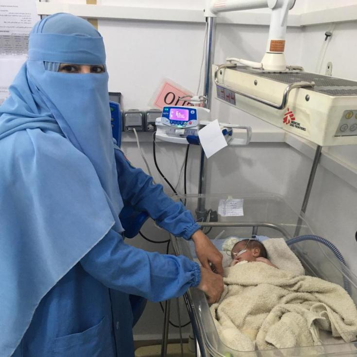 Enfermera de Médicos Sin Fronteras junto a un pequeño paciente en Yemen.