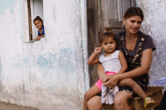 Jessica tiene 27 años de edad, vive en Tumeremo, en el Estado Bolívar al sureste de Venezuela. Está sentada en la puerta de su casa con tres de sus siete hijos. Allí pasa los días con a su madre, mientras su esposo trabaja en las minas. Su primer embrazo fue a los 14 años. Jesús Vargas.