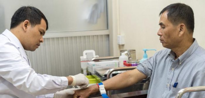 Din Savorn, de 50 años, recibe un análisis de sangre por parte de un técnico de laboratorio en la clínica de MSF Hepatitis C en el Hospital Preah Kossamak en Phnom Penh, Camboya, 20 de abril de 2017. ©Todd Brown/MSF