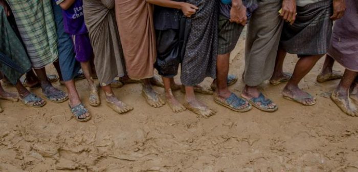Los Rohingya recién llegados forman una fila mientras esperan para recolectar materiales para construir sus refugios, que son distribuidos por agencias de ayuda en Kutupalong, Bangladesh. ©Dar Yasin/AP Photo