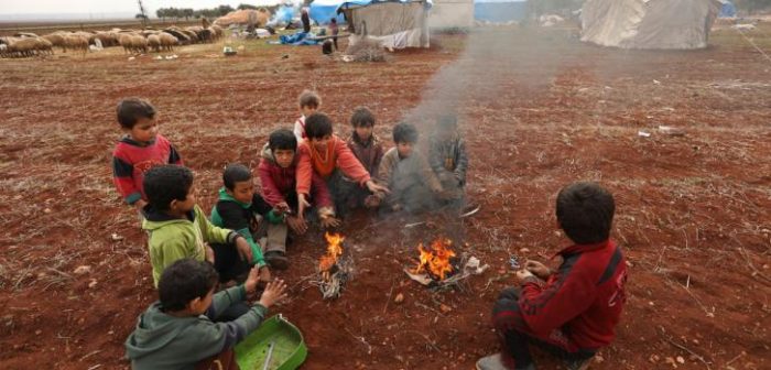 Más de 212.000 sirios tuvieron que huir de sus casas debido a la intensificación de los ataques aéreos en el noreste. La mayoría tiene muy poco o nada para mantenerse a sí mismo a medida que se acerca el invierno. Aquí, un grupo de niños sirios se acurruca cerca de un fuego para encontrar calor. ©Omar Haj Kadour/MSF