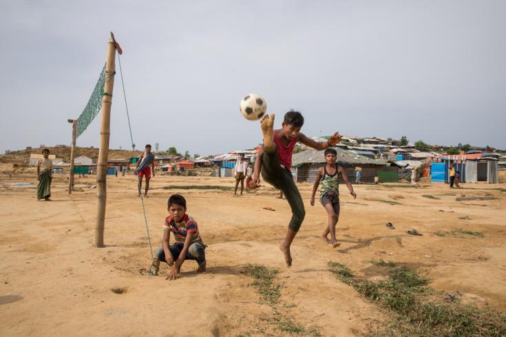 Niños jugando al fútbol en un terreno donde los refugios fueron retirados, ya que se encontraban en una zona de riesgo de monzón, en el campo de refugiados de Kutupalong, en Bangladesh.