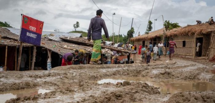 Los refugiados rohingya caminan por un camino embarrado después de las lluvias torrenciales en el campo de refugiados de Unchiprang. Decenas de miles de refugiados que viven en los campos en Cox's Bazar corren sufren inundaciones y deslizamientos de tierra durante la temporada del monzón.Daphne Tolis/MSF