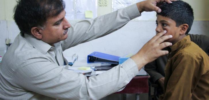 Un paciente siendo atendido en el centro especializado en el tratamiento de la leishmaniasis cutánea en Peshawar, Pakistán. El paciente es Mohammad Asif, de 11 años, quien tiene una lesión en uno de sus ojos. Él y su padre viajan durante más de dos horas diariamente para llegar al centro y que reciba tratamiento.Nasir Ghafoor/MSF