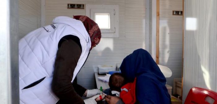 Una mujer siria desplazada junto a su hijo siendo atendido por desnutrición en la clínica móvil de Médicos Sin Fronteras en el campamento de Qadimoon, al noroeste de Siria.MSF