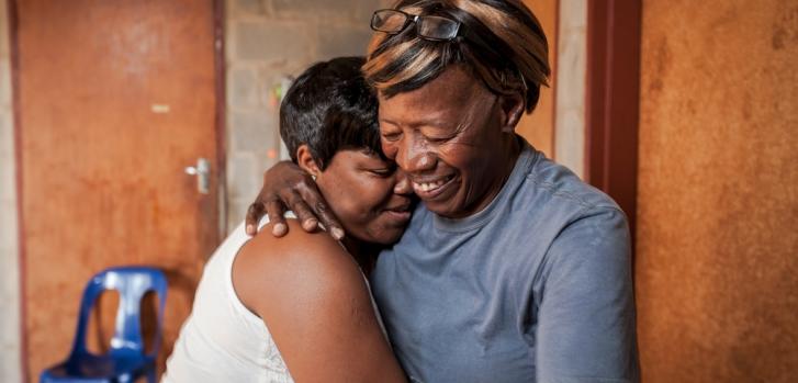 La cuidadora comunitaria Nonhlanhla Ngema en Sudáfrica abraza a un miembro de su grupo con VIH positivo.Greg Lomas/MSF
